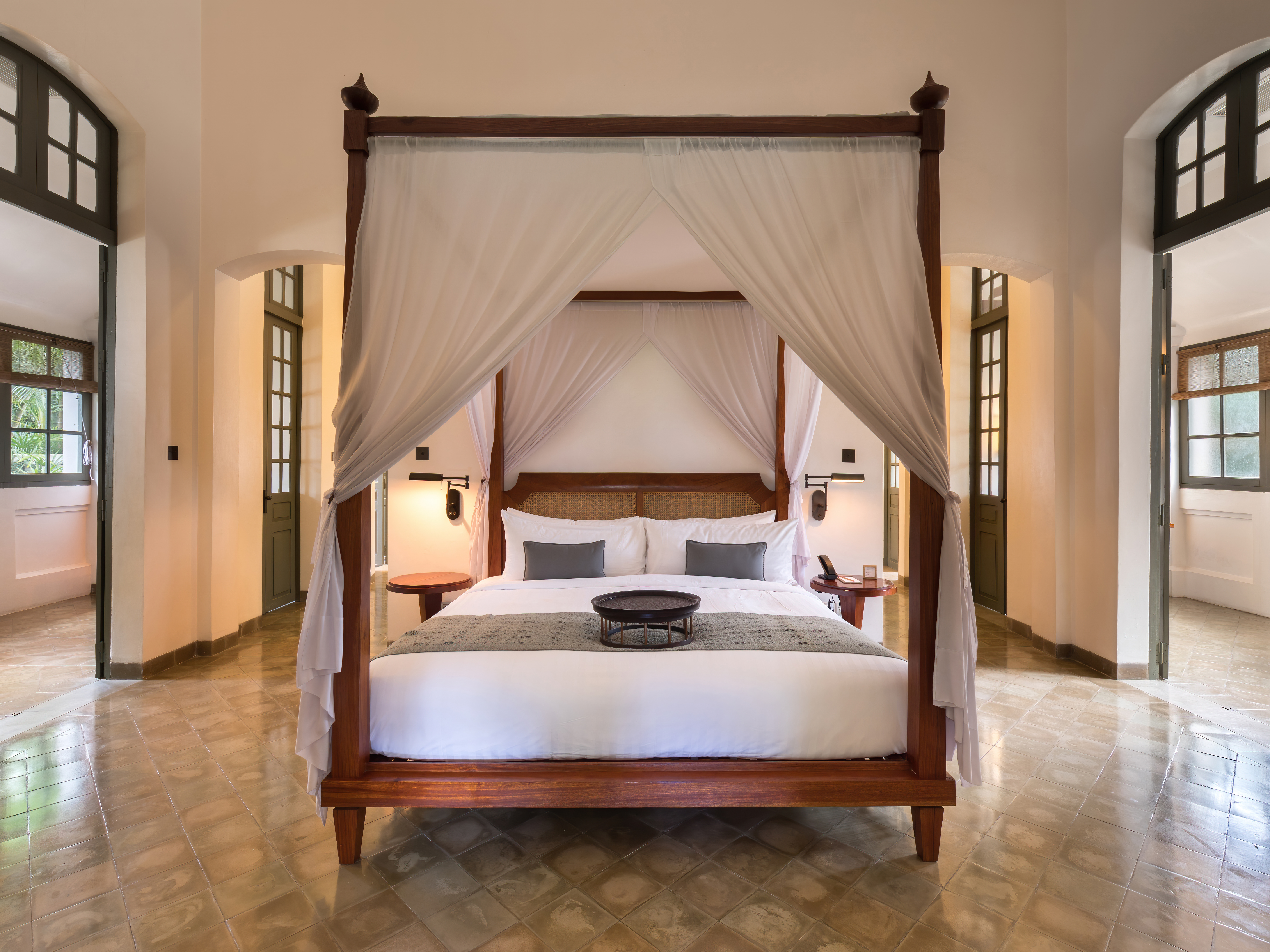 Spacious guest room with a canopy bed and seating area